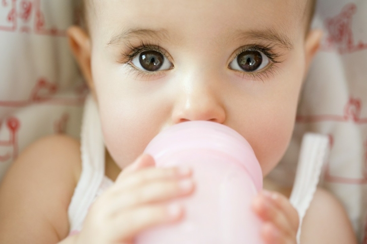 dziecko pijące mleko z butelki